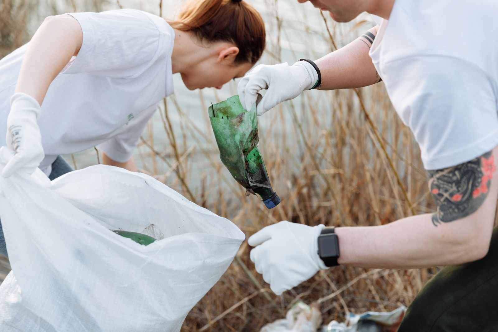 Two volunteers picking up litter with gloves and collection bags