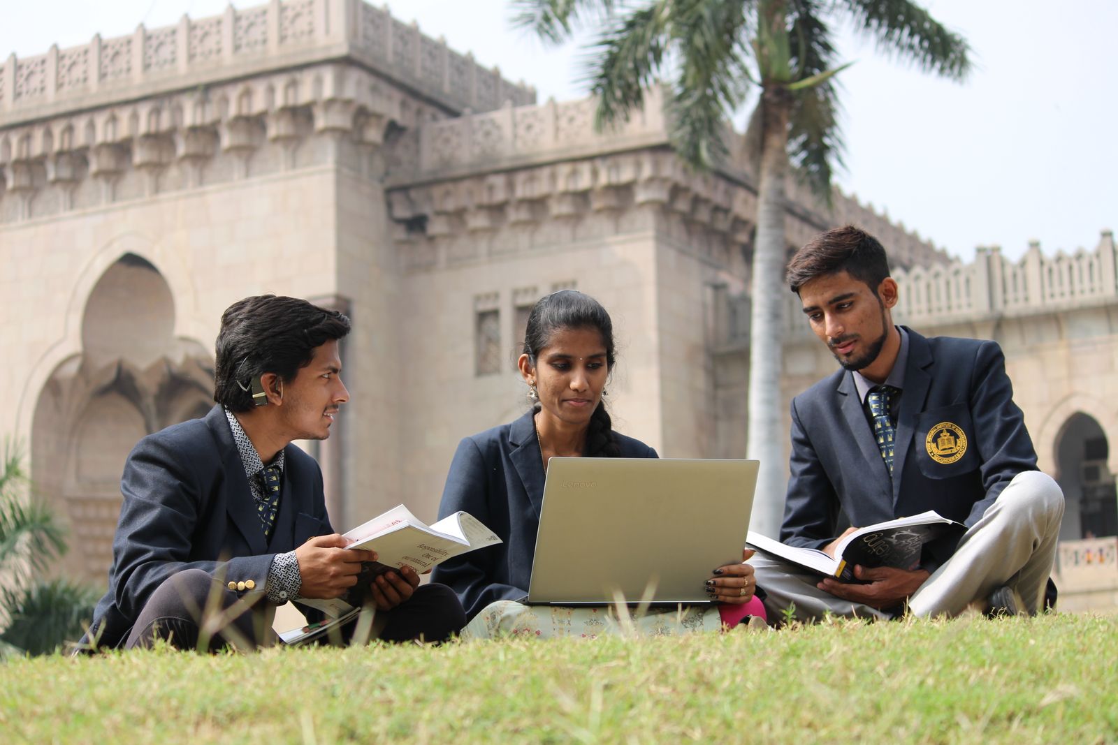 Young students in India studying together with books and a laptop